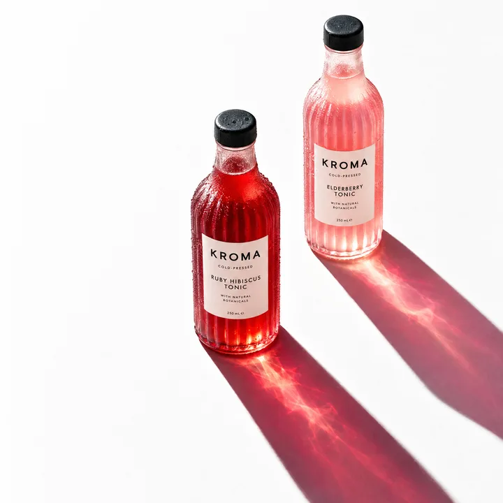 KROMA tonic: two bottles casting colored shadows.