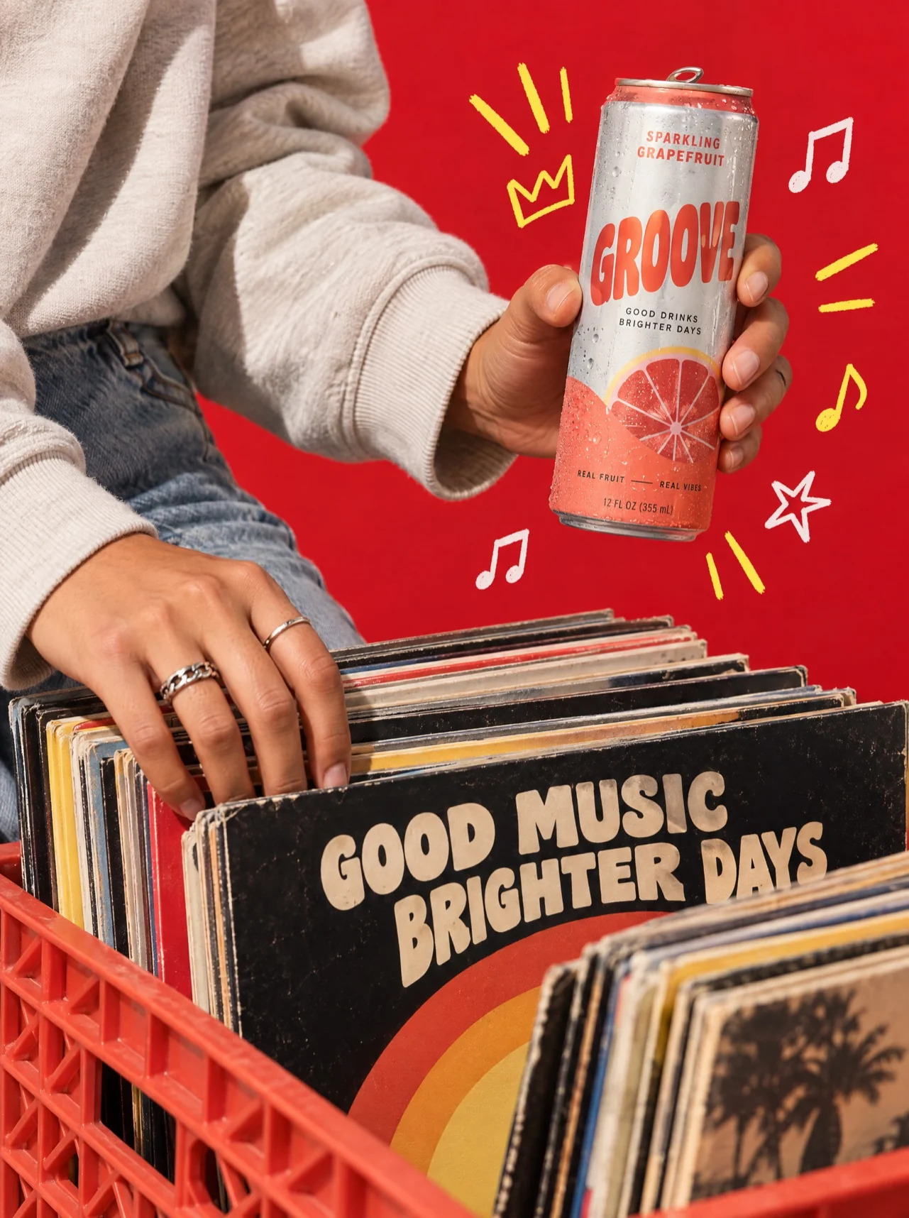 A drink held over a crate of vinyl records