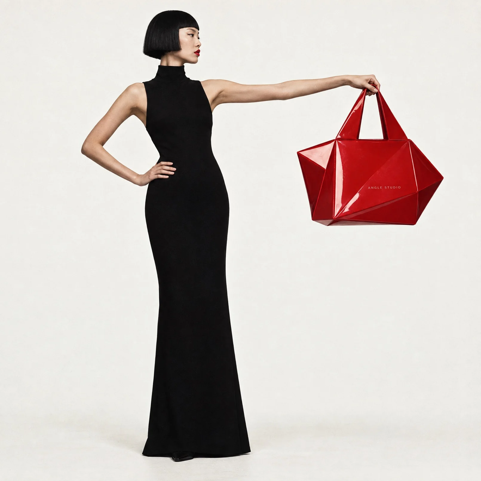 A model in a black gown holding a sculptural red bag